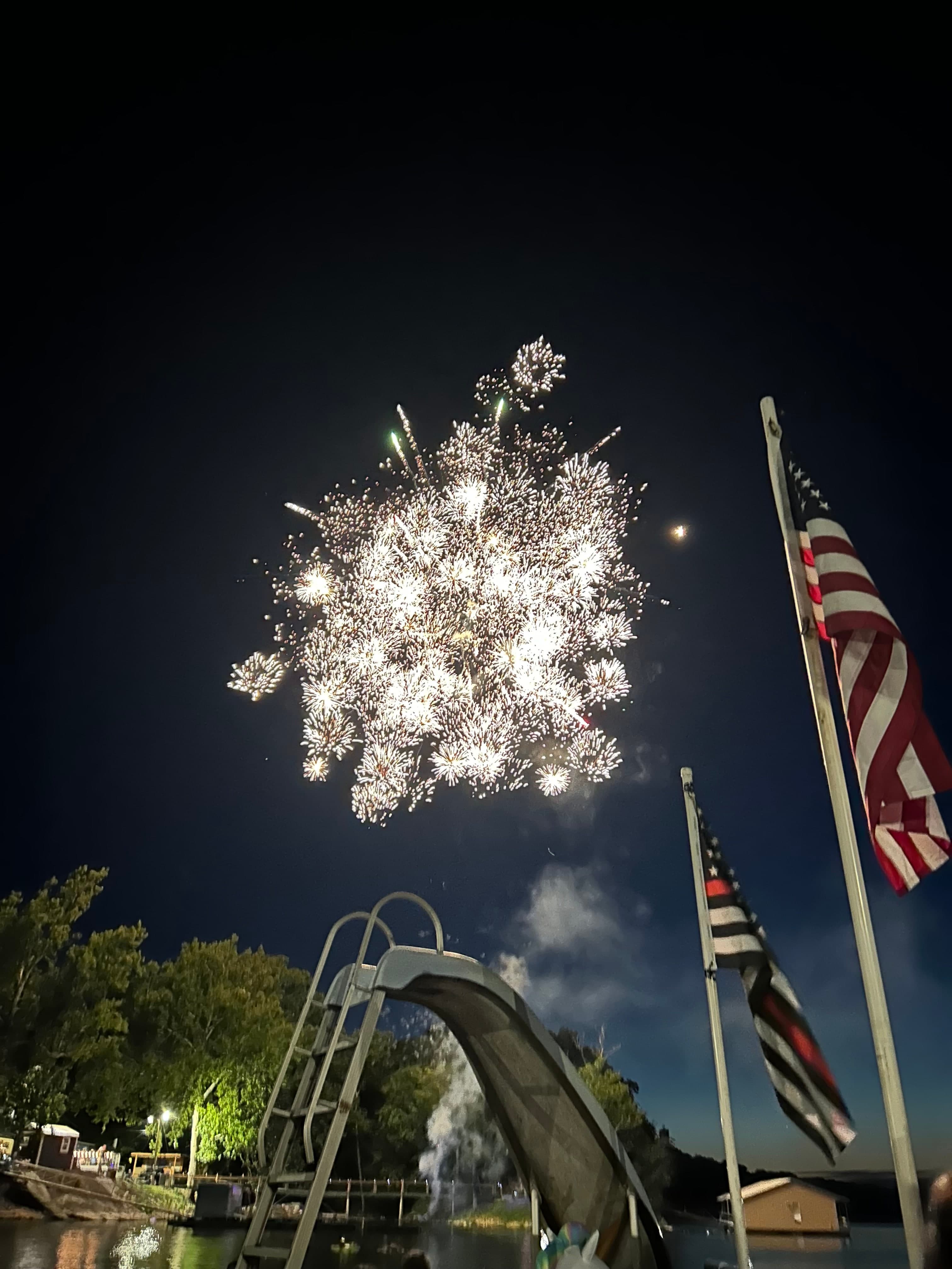 Fourth of July fireworks over the dock with American flags
