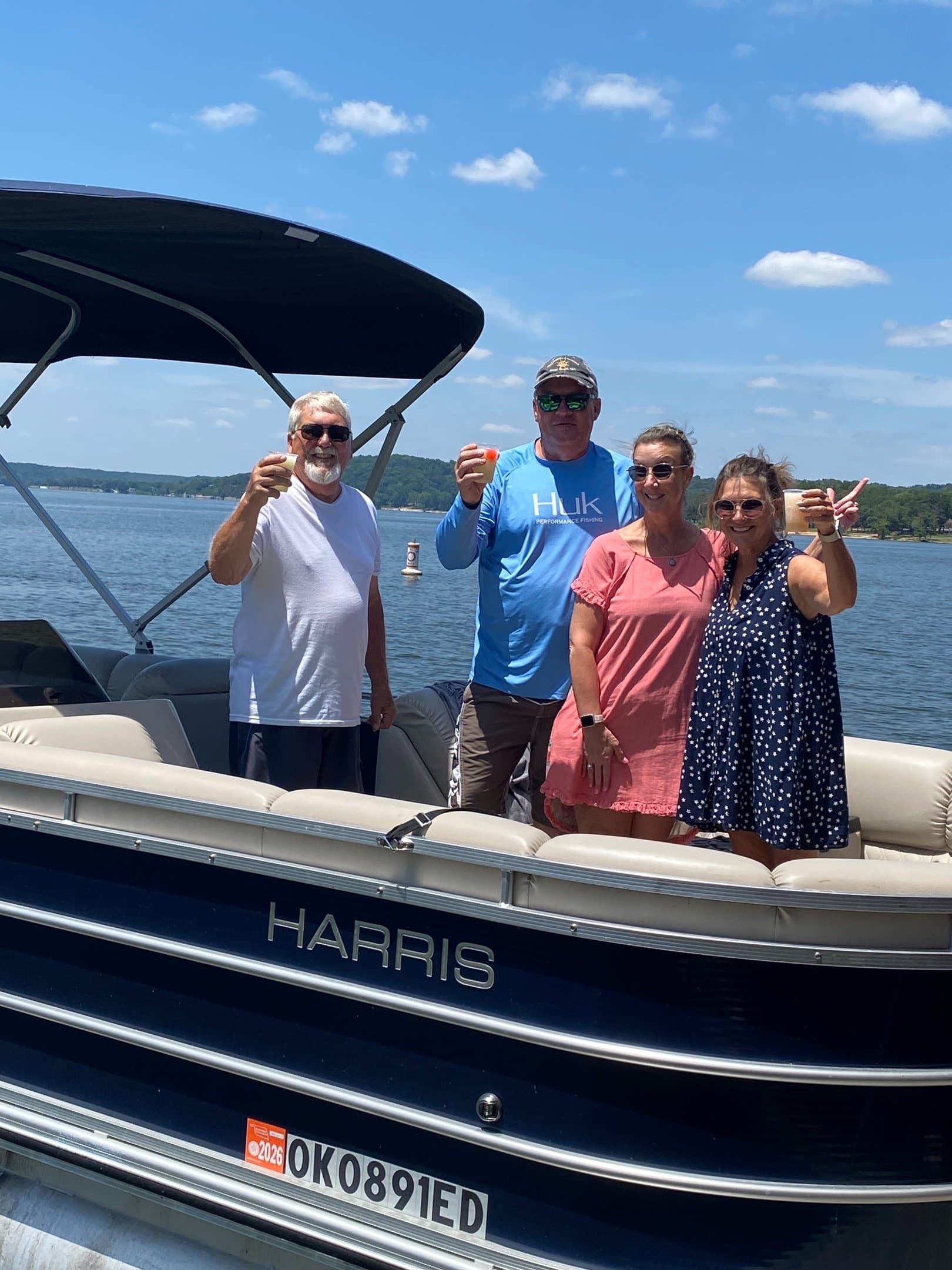 Two couples on a pontoon at the dock raising a toast