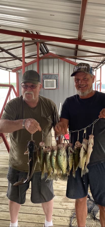 Two guests holding a stringer of crappie