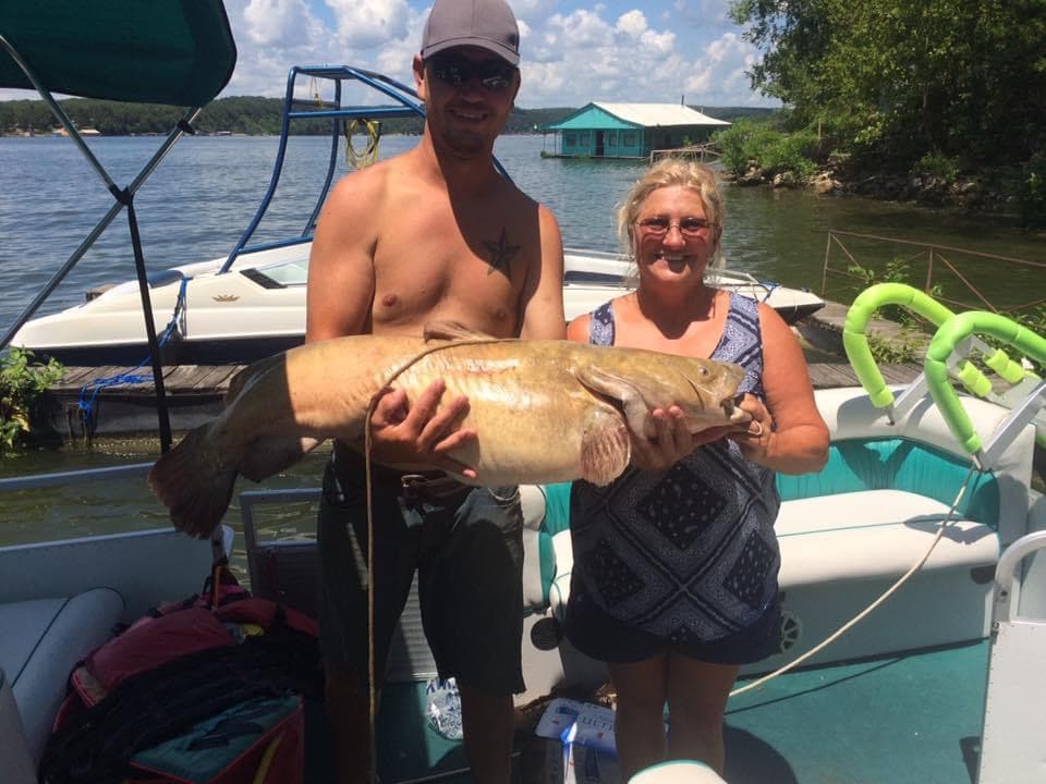 A guest and Sharon with a large flathead catfish